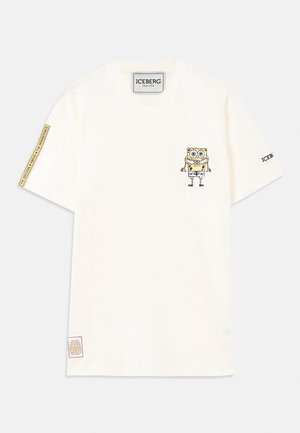 T-shirt branco de manga curta com um pequeno gráfico do cartoon SpongeBob no lado esquerdo do peito e patches de texto na manga direita e na bainha inferior.
