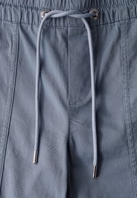 Ljust blåa shorts med dragsko och elastisk midja, utrustade med ett strukturerat tyg, metallöglor och kontrasterande dragsko.