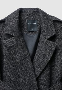 Cappotto grigio scuro intrecciato con colletto con risvolto, design monopetto, fodera interna e etichetta della taglia "S".