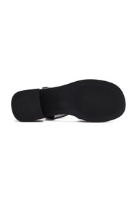 Black shoe sole with textured grip pattern, flat design, and contoured shape. Smooth edges and minimal detailing enhance functionality.
