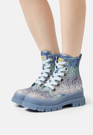Glittering ankle boots featuring an ombre design with shades of blue, silver, and lavender, secured with light blue laces and a chunky sole.