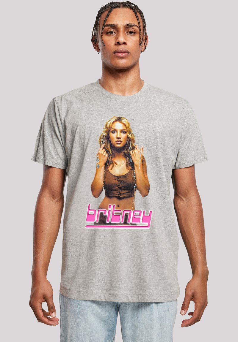 Graues T-Shirt mit kurzen Ärmeln, das eine gedruckte Grafik einer Frau zeigt, mit dem Text "britney" in Pink und einem kontrastierenden braunen Hintergrund.