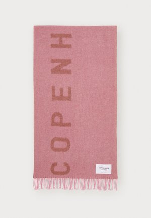 Roze wollen sjaal met bruine verticale tekst "COPENH" en franjes aan de randen, voorzien van een wit label met de tekst "Copenhagen Studios".