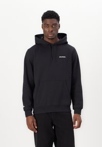 Haut à capuche noir en mélange de coton, doté d'une poche kangourou, d'une capuche avec cordon de serrage et d'un logo blanc sur la poitrine et la manche. Tissu texturé.