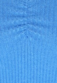 Maglione azzurro chiaro a maglia con texture a coste verticali e forma aderente, che mette in risalto il suo materiale morbido e elastico e il design senza cuciture.