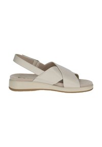 Beżowy sandał z krzyżującymi się paskami i paskiem z tyłu. Posiada płaską podeszwę, teksturowaną wkładkę i subtelny beżowy kolor.
