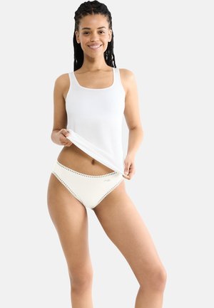 Weißes Tanktop mit quadratischem Ausschnitt. Cremefarbene Unterhose mit Spitzenbesatz. Glatte Texturen und schlichtes Design.