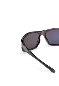 Černé plastové sluneční brýle s tmavými skly. Elegantní tvar obrouček s modrými akcenty na spáncích. Lehký a sportovní design.