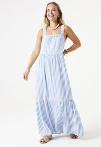 Maxikleid mit blauen und weißen Streifen, quadratischem Ausschnitt, verstellbaren Trägern, gerafftem Taillenbereich und mehrlagigem, rüschendem Saum. Aus leichtem Stoff.