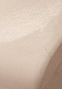 Tessuto a trama beige con una superficie liscia e una leggera lucentezza, caratterizzato da una finitura fine e patterns. I bordi curvi sono visibili nelle pieghe del tessuto.