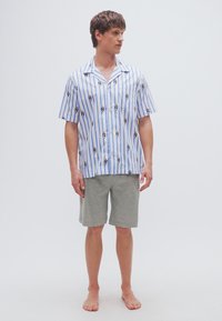 Πουκάμισο με κοντά μανίκια και γιακά, με μπλε και λευκές ρίγες, διακοσμημένο με μικρό μοτίβο πάντα· συνοδευόμενο από γκρι σορτς. Μαλακό βαμβακερό υλικό.