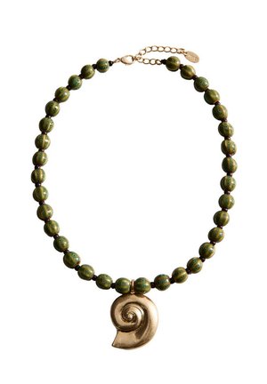Collier avec des perles rondes vertes et un grand pendentif coquillage en spirale dorée avec fermoir chaîne en or ajustable.