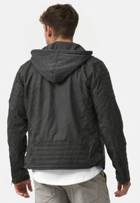 Schwarze Lederjacke mit grauem Kapuzen, ausgestattet mit gerippten Schulterakzenten, Seiteneingriffen und tailliertem Schnitt, von hinten betrachtet.