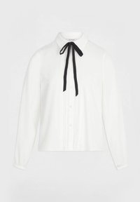 Blusa bianca a maniche lunghe con fronte plissettato, chiusura con bottoni, colletto a punta e nastro nero annodato a fiocco al collo.