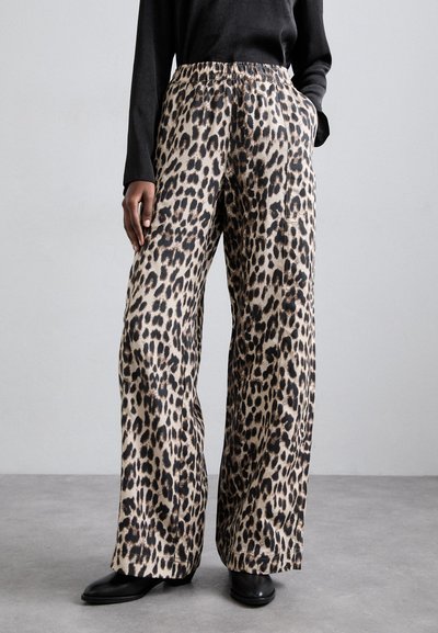 Pantaloni cu imprimeu leopard, cu picioare largi, dintr-un material neted, având un talie elastică și buzunare laterale. Botine negre la glezne completează ținuta.