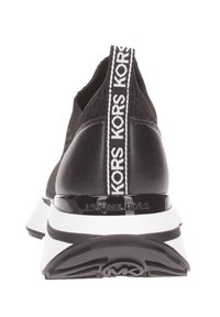 Baskets noires avec tige en mesh, accents blancs et une languette avec logo. Présente une semelle intermédiaire blanche et une semelle extérieure texturée noire.