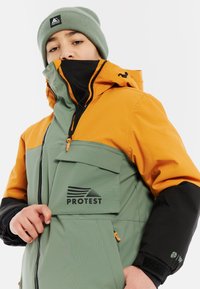 Farbblockierte Jacke mit olivgrünen, orangenen und schwarzen Paneelen, einer Fronttasche, Logodetail und einem hohen Kragen für Wärme.