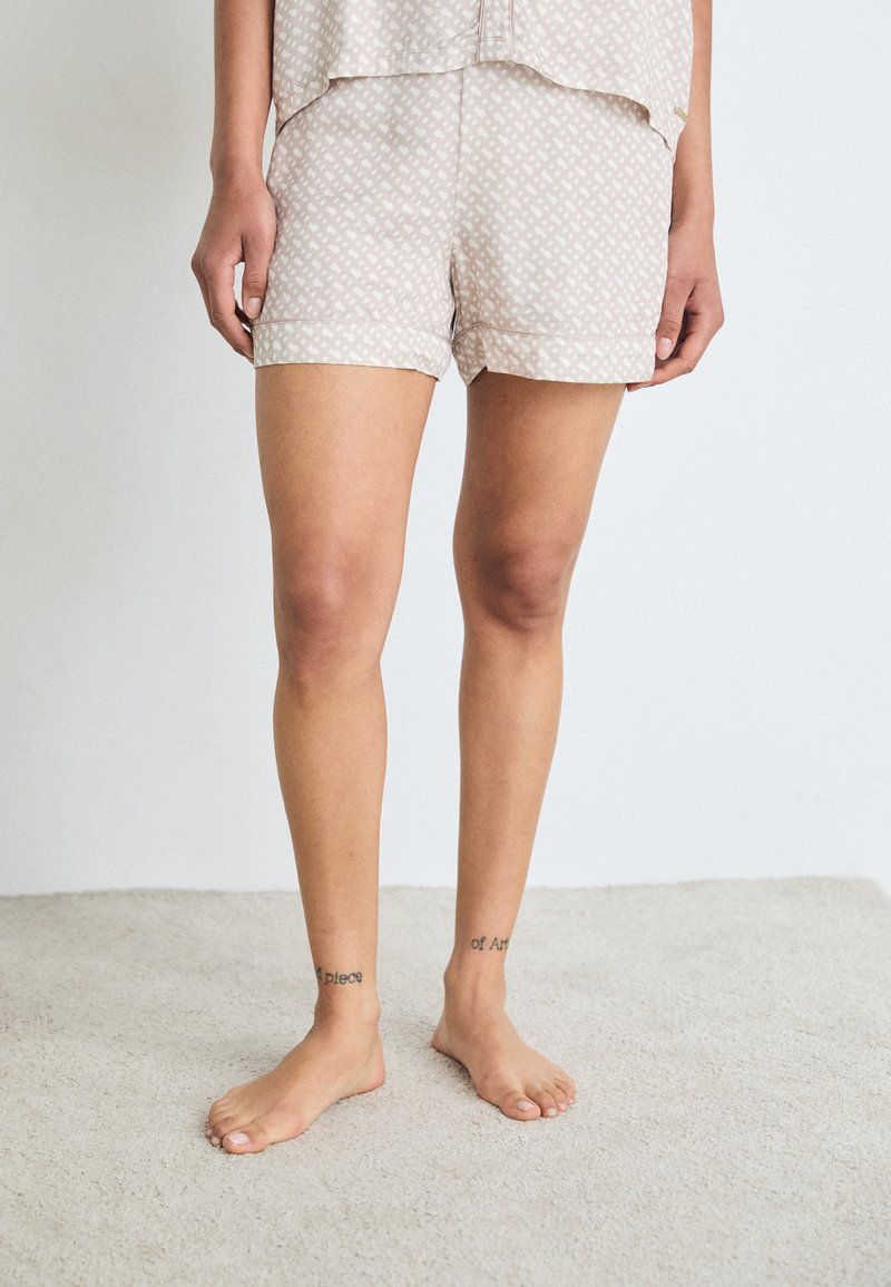 Beige mönstrade sovshorts med avslappnad passform, med en geometrisk design, mjukt tyg och en fåll som slutar vid mitten av låret.
