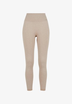 Leggings beiges côtelés avec une taille haute, fabriqués à partir d'un tissu doux et extensible pour le confort et la liberté de mouvement.