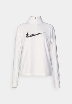 Haut de sport blanc à manches longues avec fermeture éclair quart de zip et logo Nike swoosh noir à motif sur la poitrine, sur fond uni.