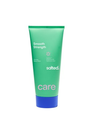 Tube vert de lotion pour le corps raffermissante salée Smooth Strength avec SeaSync et acide hyaluronique, bouchon bleu, et le mot care en rose.