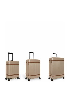 Drei beigetöne Hartschalenkoffer mit vier Rädern und ausgezogenen schwarzen Griffen, nach Größe von klein bis groß auf weißem Hintergrund angeordnet.