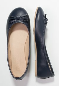 Ballerine blu navy realizzate in materiale sintetico liscio. Presentano una punta arrotondata e un piccolo fiocco decorativo sulla parte anteriore. Interno della soletta color sabbia.
