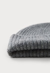 Γκρι ριγωτό πλεκτό σκουφάκι με διπλωμένη μανσέτα, φτιαγμένο από υλικό με υφή, που έχει μια ζεστή εμφάνιση και μαλακή υφή.