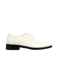 Chaussure Oxford en cuir blanc avec semelle et talon noirs, laçage fermé et talon bas empilé, vue de profil sur fond blanc.