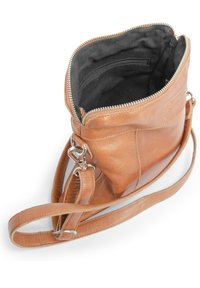 Tan läder crossbody-väska med dragkedja upptill, utrustad med en svart tyginredning och en silverfärgad hårdvaruklämma. Väskan har en mjuk textur och en minimalistisk design.