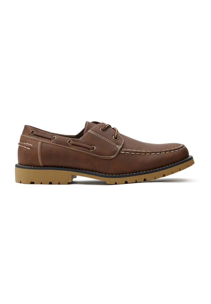 Zapato de cuero marrón con un acabado texturizado, costuras blancas, cordones redondos y una suela de goma con un patrón de relieve definido.