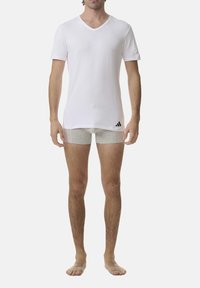 White V-neck t-shirt made of cotton, short sleeves, paired with gray boxer briefs. The t-shirt features a black Adidas logo on the left side.