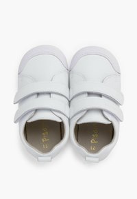 Scarpe in pelle bianca con doppie fascette in velcro, punte arrotondate e interno morbido. Presentano una suola in gomma testurizzata e un logo dorato impresso all'interno.