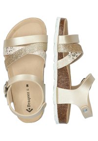 Sandalias doradas con tiras cruzadas, con detalles brillantes y un diseño de print de leopardo. Plantilla de corcho, suela blanca, hebillas ajustables.