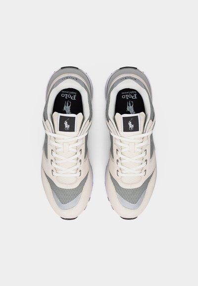 Par de zapatillas Polo Ralph Lauren blancas y grises con cordones, vistas desde arriba, mostrando las plantillas con la marca y el logo en la lengüeta.