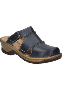 Navy blue leather clog with open-toe design, cross straps, and beige stitched rubber sole. Textured side accents highlight the design.