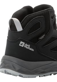 Zwarte wandelschoen met een gestructureerde bovenkant, gaaspanelen en een grijze geprofileerde zool. Aan de zijkant staat het Jack Wolfskin-logo en de branding.