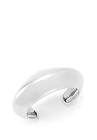 Bracelet en métal argenté avec un design lisse et arrondi et une finition polie. Présente des extrémités légèrement pointues pour un port facilité.