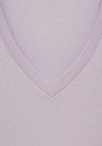 Tricou V cu guler de culoare violet deschis, cu o textură netedă și cusături curate. Gulerul are o formă triunghiulară subtilă și este finisat uniform.