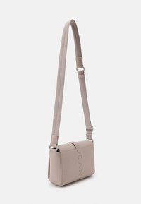 Tommy Jeans CITY BOLD FLAP CROSSOVER - Taška s příčným popruhem - drifty dunes