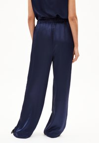 Navyblaue Satin-Hosen mit weiter Beinform, elastischem Bund, glatter Textur und zarten Quasten an dem Saum.