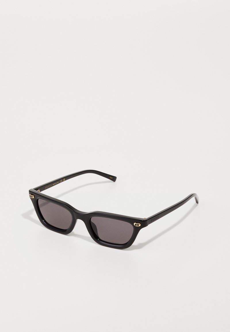 Black rectangular sunglasses with dark lenses, gold accents on the temples, and a matte finish on the frame. Classic design.