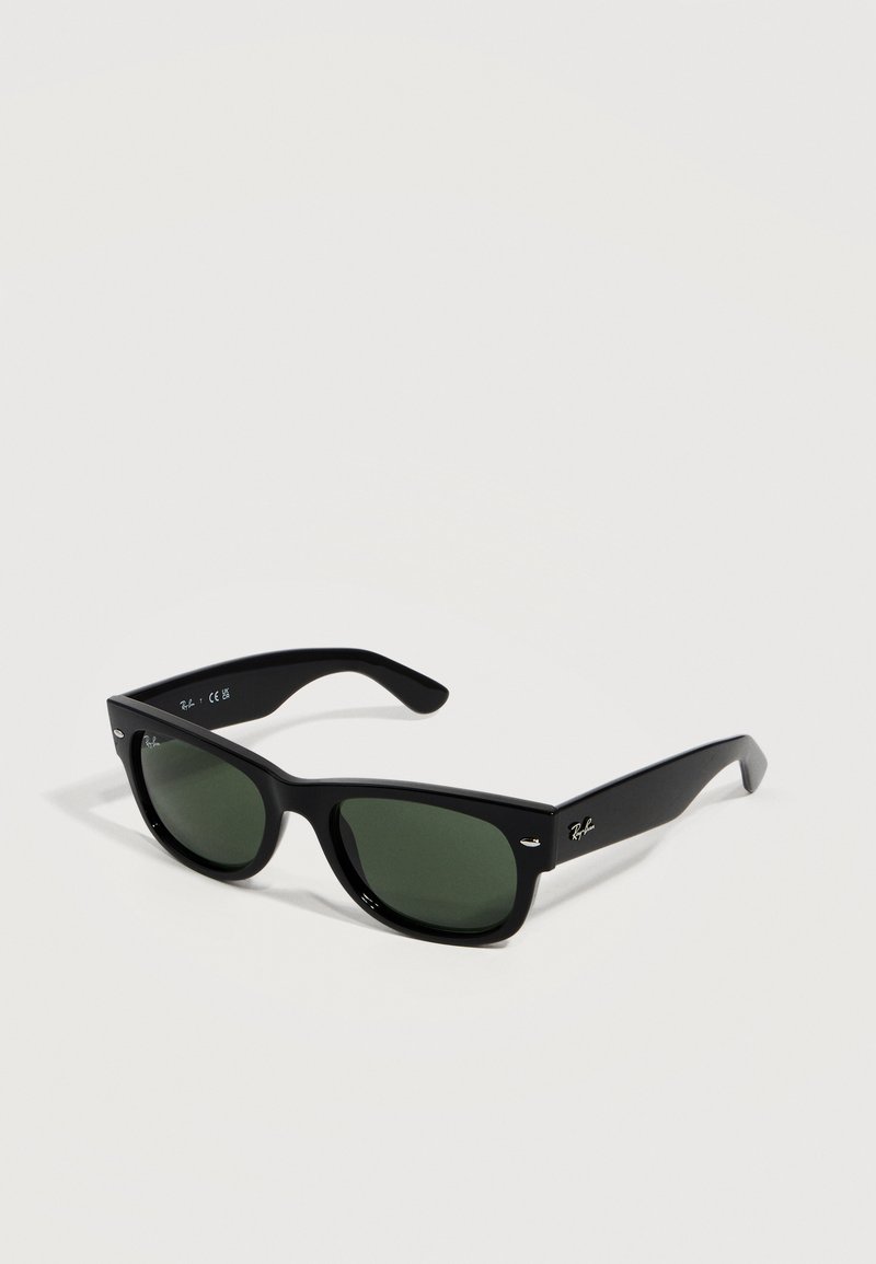 Μαύρα γυαλιά ηλίου Ray-Ban Wayfarer με σκούρους πράσινους φακούς και χαρακτηριστικό λογότυπο στα πλαϊνά, τοποθετημένα σε ανοιχτόχρωμη επιφάνεια.