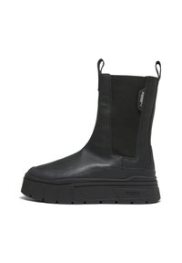 Musta nahkasaapas mid-calf-pituudella, paksu kumipohja, joustavat sivupaneelit, vetotapit ylhäällä ja Puma-logo sivussa ja pohjassa.