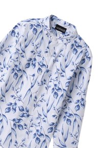 Camicia di stoffa bianca con motivo floreale blu, colletto alla cinese e due bottoni davanti. Tessuto leggero e superficie liscia.