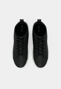 Sorte høye sneakers med glatt tekstur, flate snøring, en pull-tab på hælen, og en hvit gummisåle. Merkenavn trykt inni.
