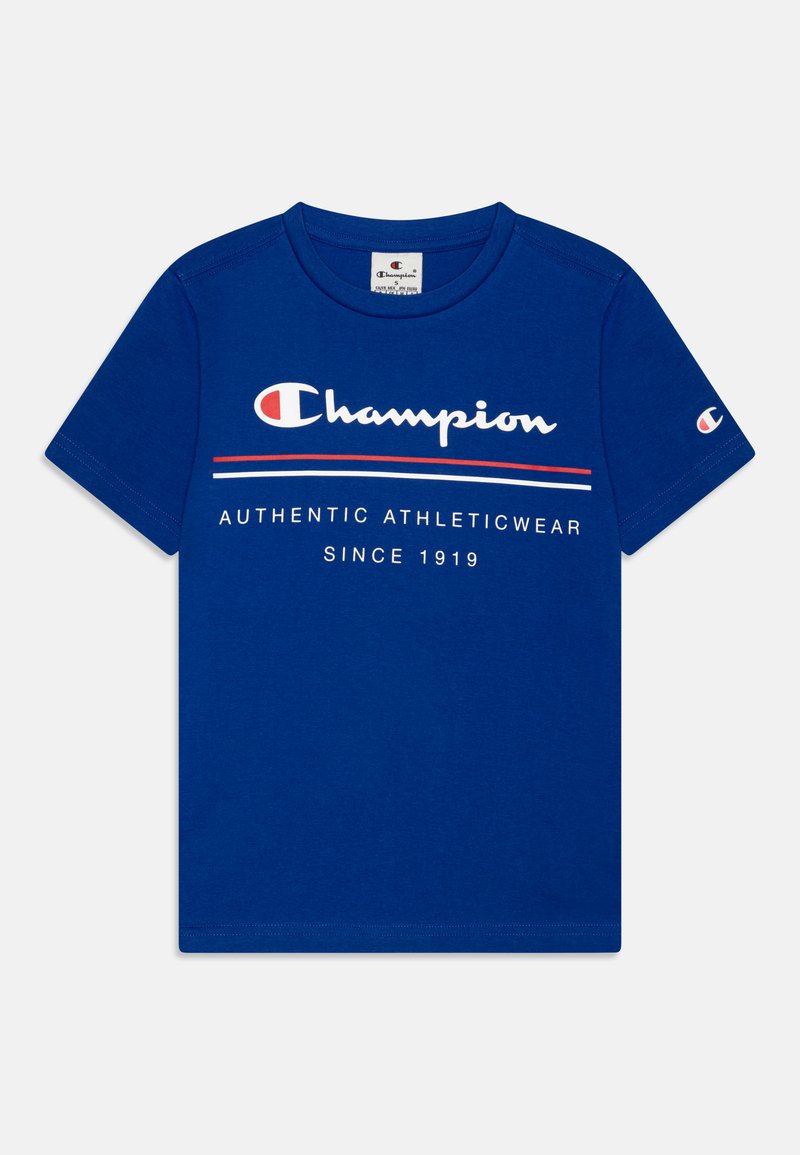 Blå bomull t-skjorte med korte ermer, med hvit og rød tekst som leser "Champion AUTHENTIC ATHLETICWEAR SINCE 1919" på forsiden.