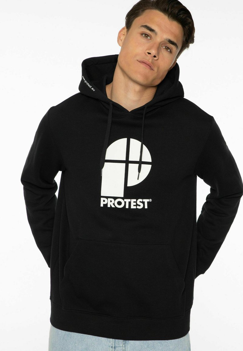 Felpa nera con cappuccio realizzata in un tessuto morbido, caratterizzata da un grande logo circolare bianco con un design a croce e testo. Include una tasca frontale e cordini per il cappuccio.
