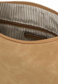 Innenraum einer tanfarbenen Wildlederhandtasche, mit gestreiftem braunem Futter, einer Reißverschlusstasche und einem gestickten Etikett. Glatte Textur und subtiler Glanz.