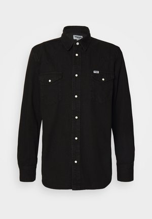 Camisa preta de botão com colarinho pontudo, dois bolsos no peito, botões de pressão brancos e tecido texturizado. Logotipo da Wrangler no lado esquerdo do peito.